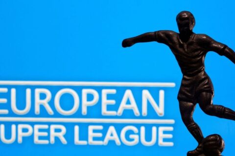 A metal figure of a football player with a ball is seen in front of the words "European Super League" in this illustration taken April 20, 2021. REUTERS/Dado Ruvic/Illustration/File Photo